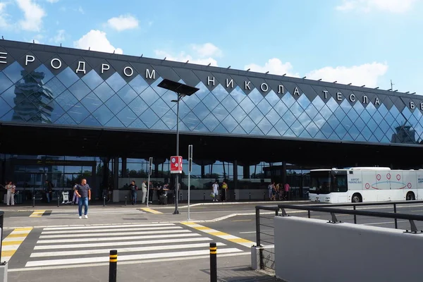 Belgrad, Sırbistan 09.17.2023 Nikola Tesla Uluslararası Surcin Havaalanı. Yeni havaalanı binaları. Uçakla uçan yolcu trafiğini arttır. Arabalar, insanlar, otobüs durağı, park yeri. Cam havaalanı duvarları.