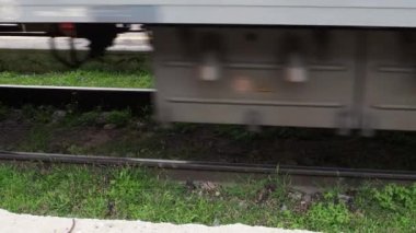Yolcu treni hızlı koşar. Demiryolları. Arabalar, pusucular ve raylar. Ulaşım endüstrisi. Bir tren dolusu kargo konteynırı geçiyor. Demiryollarında yeşil zarafet.