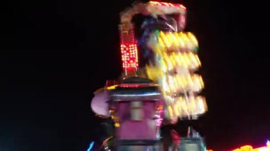 Anapa, Rusya 11.12.23 Çılgın heyecanlı yolculuk. İki boyutlu atlıkarınca eylemsiz dönüş. Geceleyin bir lunapark. Döner kavşak, atlı karınca. Yüksek adrenalinle tehlikeli bir eğlence.