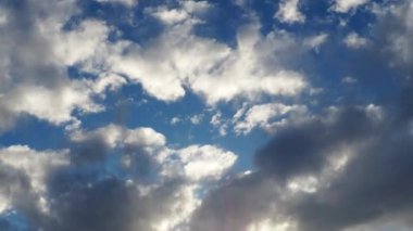 Gökyüzünde güzel bulutlar. Ses ötesi ışık efekti. Güneş ışınları yaklaşan kara bulutların arkasında gizlidir. Kümülüs bulutları. Atmosferde muhafaza. Zaman aşımı. İklim ve hava