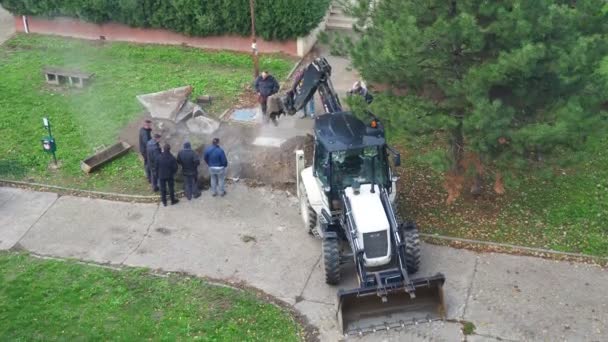 Sremska Mitrovica Serbia 拖拉机与桶挖土 压碎沥青 社区服务的问题 暖气总管的修理 地下管道损坏了 蒸汽流动 — 图库视频影像