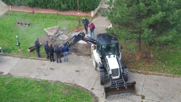 Sremska Mitrovica Serbia 拖拉机与桶挖土 压碎沥青 社区服务的问题 暖气总管的修理 地下管道损坏了 蒸汽流动 — 图库视频影像