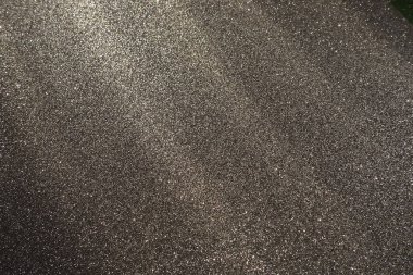 Siyah bir yüzey üzerindeki belirsiz ışık ışınları. Bokeh, toz parçacıkları, yansıma ve büyülü parıltı. Parlak arka plan şenliği. Yeni yıl, Noel, doğum günü. Plastik kart tasarımı. Kozmik foton yıldız uzayı