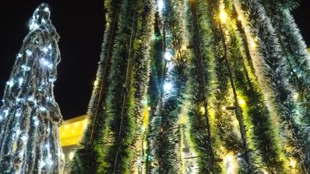 明けましておめでとうございます クリスマスツリー シルバー ホワイト 黄色と黄金の燃える球根の装飾 バックグラウンドボケ 家族の冬の休日のための電球ガーランドを明るくする フェスティバル ノエルムード — ストック動画