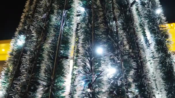 明けましておめでとうございます クリスマスツリー シルバー ホワイト イエロー ブルーの燃える球根の装飾 バックグラウンドボケ 家族の冬の休日のための電球ガーランドを明るくする フェスティバル ノエルムード — ストック動画