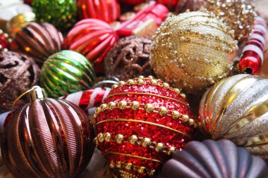 Yılbaşı baloları ve dekorasyonlar kapanıyor. Bir sürü altın dekor, kırmızı, sarı, kahverengi, yeşil, gümüş. Çizgili Noel topları bir demet yalan söyler. Neşeli, güzel, renkli bir arka plan. Tasarım.