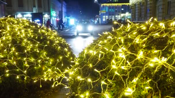 スレムスカ ミトロヴィツァ セルビア 黄金のガーランドを輝かせるクリスマスの新年 冬のデコレーション お祝いデザイン都市広場 フェスティバルノエルXmas 車が運転し 人々が通りを歩いている — ストック動画