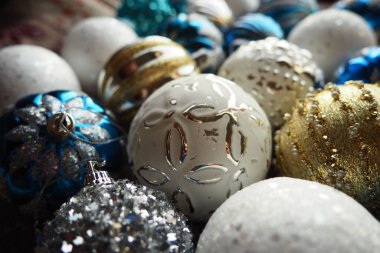 Yılbaşı baloları ve dekorasyonlar kapanıyor. Bir sürü altın, mavi, sarı, beyaz, gümüş madalya. Çizgili Noel topları yüzeyde yatıyor. Neşeli, güzel, renkli bir arka plan. Tasarım