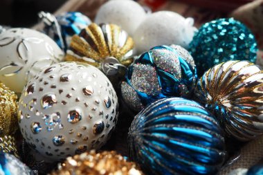 Yılbaşı baloları ve dekorasyonlar kapanıyor. Bir sürü altın, mavi, sarı, beyaz, gümüş madalya. Çizgili Noel topları yüzeyde yatıyor. Neşeli, güzel, renkli bir arka plan. Tasarım