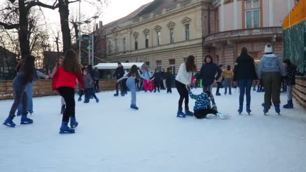セルビアのスレムスカ ミトロヴィツァ 2023年12月28日 シティアイスケートリンク 子供と大人は楽しさと喜びで冬の日にスケートを楽しんでいます スクール休憩 クリスマスと年末年始 多くの人々 — ストック動画