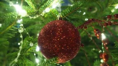 Noel ağacı süslemeleri. Kırmızı cam mücevher. Mutlu yıllar Noel ağacı. Dalda güzel bir top. Kış tatilinde aile tatili için bir sürü yanıp sönen ampul. Festival havası. Noel.