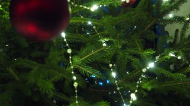 Noel ağacı süslemeleri. Kırmızı cam mücevher. Mutlu yıllar Noel ağacı. Dalda güzel bir top. Kış tatilinde aile tatili için bir sürü yanıp sönen ampul. Festival havası. Noel.