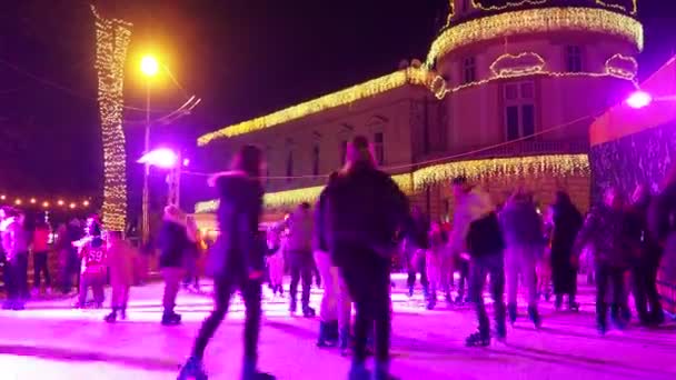 セルビアのスレムスカ ミトロヴィツァ 2023年12月28日 シティアイスケートリンク 子供と大人は冬の夜の楽しみと喜びでスケートを楽しんでいます スクール休憩 クリスマスと年末年始 ピンク ライト — ストック動画