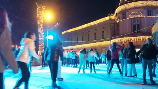 セルビアのスレムスカ ミトロヴィツァ 2023年12月28日 シティアイスケートリンク 子供と大人は冬の夜の楽しみと喜びでスケートを楽しんでいます スクール休憩 クリスマスと年末年始 多くの人々 — ストック動画