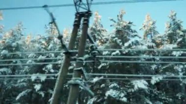 Karlı bir peri masalına kış treni yolculuğu. Hareket eden bir aracın penceresinden karla kaplı bir tayga ormanına bakın. Kar yığınları, ladin ve çam ağaçları kar altında. Karelia 'nın Doğası.