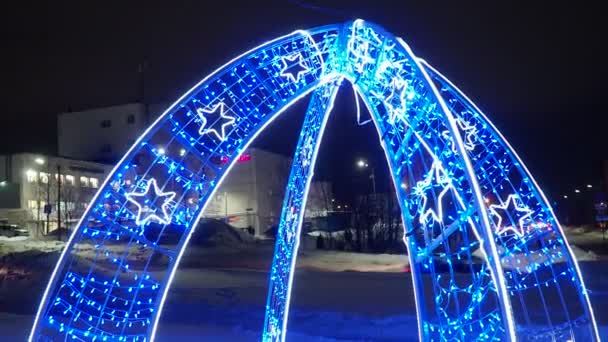 ペトロヴァオドスク カレリア ロシア 新しい年は装飾と点滅ライトで装飾的なアーチを輝かせます ブルーとホワイトガーランド ホリデーデコレーション レトロ 冬の夜 ショッピングセンター — ストック動画