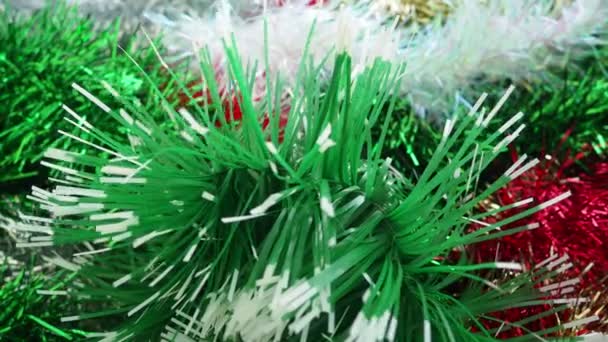 レッド ホワイト グリーン ゴールデンカラー クリスマスツリー インテリアまたはパーティールームのための新年のクリスマスの装飾 スレッドホイルを織る 美しい光沢のある背景をお祝いします クローズアップ — ストック動画