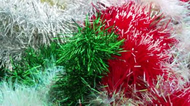 Kırmızı, beyaz, yeşil ve altın rengi Tinsel yağmuru. Noel ağacı, iç mekan ya da parti odası için yılbaşı süslemeleri. Folyo örüyorum. Şenlikli, güzel, parlak arka plan. Tinsel yakın çekim