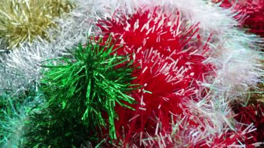 Kırmızı, beyaz, yeşil ve altın rengi Tinsel yağmuru. Noel ağacı, iç mekan ya da parti odası için yılbaşı süslemeleri. Folyo örüyorum. Şenlikli, güzel, parlak arka plan. Tinsel yakın çekim
