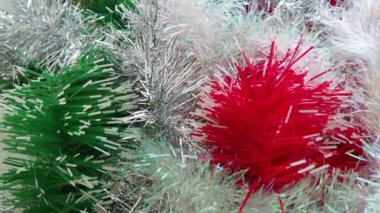 Kırmızı, beyaz, yeşil ve altın rengi Tinsel yağmuru. Noel ağacı, iç mekan ya da parti odası için yılbaşı süslemeleri. Folyo örüyorum. Şenlikli, güzel, parlak arka plan. Tinsel yakın çekim