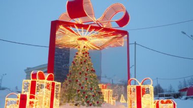 Parlak Noel ağacı şeklinde mimari formlar ve altın kırmızı çelenklerden yapılmış büyük fiyonklu hediye kutuları. Şehir sokaklarının ve meydanlarının şenlikli dekorasyonu. Noel ve Yeni Yıl