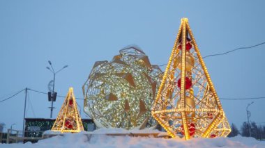 Parlak koni şeklinde küçük mimari biçimler ve altın çelenkler ve ampullerden yapılmış büyük bir koni. Şehir sokaklarının ve meydanlarının şenlikli dekorasyonu. Xmas, Noel ve Yeni Yıl Tatili 