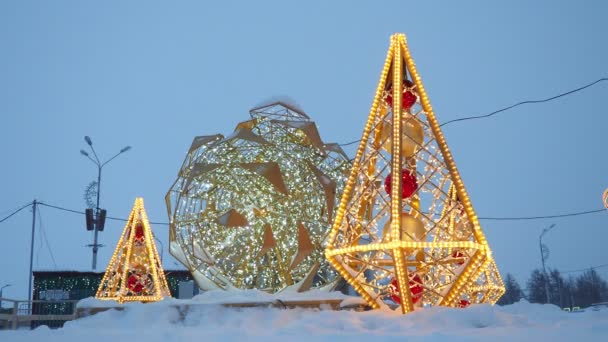 以明亮的圆锥和一个大圆锥为形式的小型建筑形式 由金色的花环和灯泡制成 城市街道和广场的节日装饰 圣诞及新年假期 — 图库视频影像