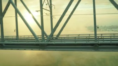 Volkhov, Rusya. Volkhov Nehri üzerindeki demiryolu köprüsü boyunca hidroelektrik santralinin yanında. Şiddetli buz -30 derece santigrat derece. Alçak kutup güneşi. Sarı soğuk sis.