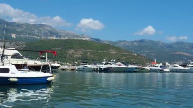 Budva, Karadağ, 15 Ağustos 2022 Adriyatik denizi, kıyı, dağlar, deniz dalgaları. Tekneler ve gemiler sete demirlediler. Su taşıma aracı. Turistik su aktiviteleriyle yaz tatili gezileri.