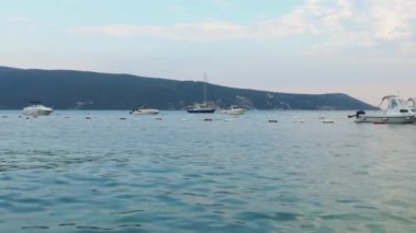 Herceg Novi Montenegro, 8 Ağustos 2022. Deniz kıyısı tatili. Deniz gezileri ve balıkçılık. Tekneler dağların arka planına karşı denizde yüzer. Hava bulutlu. Adriyatik Denizi Akdeniz seyahat şirketi