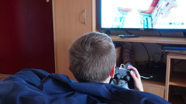 スレムスカ ミトロヴィツァ セルビア ボーイはプレイステーションでビデオゲームをプレイするためにジョイスティックを使用しています ホームビデオゲームコンソール ギャンブル中毒とコンピュータゲームへの子供の依存の開発 — ストック動画