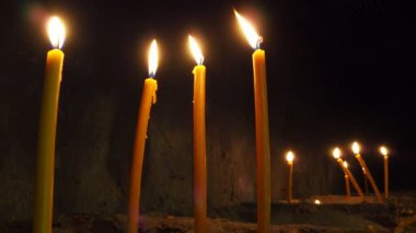 Uzun mumlar dinlenmek için yanar. Mumlu Anma Günü. Hatıra mumları. Mumlar mezarlıkta yanar. Kotor Montenegro 'daki Ortodoks Kilisesi' nde mum yakmak. Alevler sallanıyor