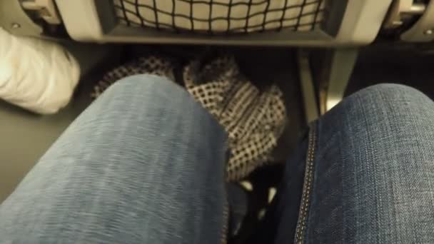 Frauenbeine Jeanshosen Einem Schmalen Spalt Zwischen Den Sitzen Flugzeug Economy — Stockvideo