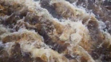 Nehirde akan su, üst manzara. Koyu demir su dereye hücum eder. Sarı-beyaz köpük. Karelia, Lososinka Nehri baharda, Onega Gölü 'ne dökülüyor. Seller, tsunami ve iklim değişikliği.