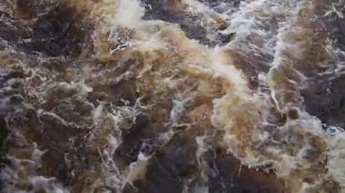 Nehirde akan su, üst manzara. Nehirde su akıyor. Sarı-beyaz köpük. Karelia, Lososinka Nehri baharda, Onega Gölü 'ne dökülüyor. Seller, tsunami ve iklim değişikliği. Yavaş çekim.