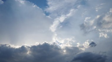 Gökyüzünde güzel bulutlar. Volumetrik ışık kümülüs etkisi. Güneş ışınları kara bulutların arkasında gizlidir. Troposferde koruma. Atmosferde nem hareketi. Gerçek zamanlı. Hava tahminleri