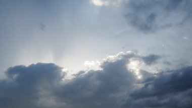 Gökyüzünde güzel bulutlar. Volumetrik ışık kümülüs etkisi. Güneş ışınları kara bulutların arkasında gizlidir. Troposferde koruma. Atmosferde nem hareketi. Gerçek zamanlı. Hava tahminleri