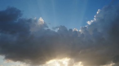 Gökyüzünde güzel bulutlar. Volumetrik ışık kümülüs etkisi. Güneş ışınları kara bulutların arkasında gizlidir. Troposferde koruma. Atmosferde nem hareketi. Hava tahminleri.