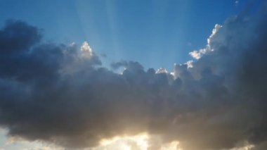 Gökyüzünde güzel bulutlar. Volumetrik ışık kümülüs etkisi. Güneş ışınları kara bulutların arkasında gizlidir. Troposferde koruma. Atmosferde nem hareketi. Hava tahminleri.