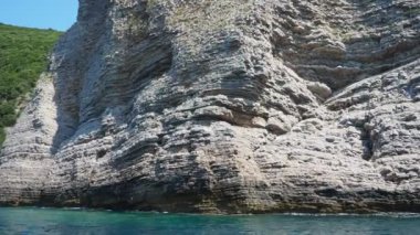 Petrovac-Sutomore arasındaki Cave Pecin körfezi. Queen Sahili. Tepeler, ulaşılamaz kayalar. Kraljicina Plaza 'da. Canj Montenegro 'da. Sinek, deniz tortulu kayalar, litolojik katmanlar. Adriyatik Akdeniz
