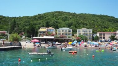 Canj Montenegro 07.21.24 Tatilciler, güneşlenenler ve yüzücülerle dolu bir tekne turu. Oteller, güneş şemsiyeleri, Adriyatik dalgaları, şamandıralar. Plaj turizmi. Tatil seyahati. Yaz günü. Kumlu çakıl taşı plajı.