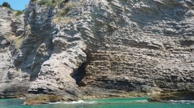 Martı ve Ratkova Kraljicina plaza Tri kralja yakınlarındaki Pecin Koyu. Tepeler, ulaşılamaz kayalar. Budva Karadağ. Sinek, deniz tortulu kayalar, litolojik katmanlar. Adriyatik Akdeniz.
