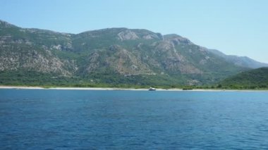 Buljarica, Budva, Karadağ 07.22.24 Buljarica Resovo brdo Koyu 'ndan Dubovica' nın en büyük plajına kadar uzanır. Tatilciler, güneşlenenler, yüzücüler. Araba kampları. Oteller, tekneler. Adriyatik Akdeniz