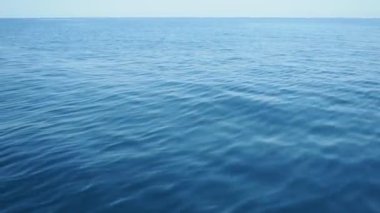 Gök mavisi Adriyatik Akdeniz yolculuğu. Mavi su yüzeyi. Seyahat, tekne gezileri, yaz tatilleri, Karadağ turizmi. Sakin, dipsiz deniz. Plaj tatili gezisi. Su dalgalanmaları. Su arkaplanı