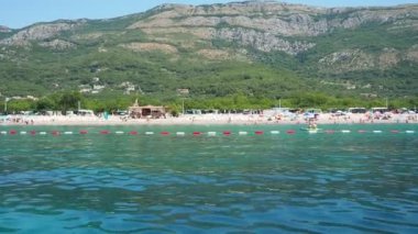 Buljarica, Budva, Karadağ 07.22.24 Buljarica Resovo brdo Koyu 'ndan Dubovica' nın en büyük plajına kadar uzanır. Tatilciler, güneşlenenler, yüzücüler. Araba kampları. Oteller, tekneler. Adriyatik Akdeniz
