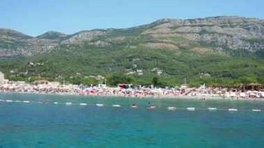Buljarica, Budva, Karadağ 07.22.24 Buljarica Resovo brdo Koyu 'ndan Dubovica' nın en büyük plajına kadar uzanır. Tatilciler, güneşlenenler, yüzücüler. Araba kampları. Oteller, tekneler. Adriyatik Akdeniz
