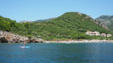 Buljarica, Budva, Karadağ 07.22.24 Buljarica Resovo brdo Koyu 'ndan Dubovica' nın en büyük plajına kadar uzanır. Tatilciler, güneşlenenler, yüzücüler. Araba kampları. Oteller, tekneler. Adriyatik Akdeniz