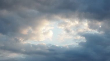 Bulutlar gökyüzünde süzülüyor, güneş aralıkları. Hava kötüleşiyor. Gün batımının zarif mavi, sarı ve pembe renkleri. Gerçek zamanlı. Yavaş bulut hareketleri. Yüksek kalite 4k görüntü.