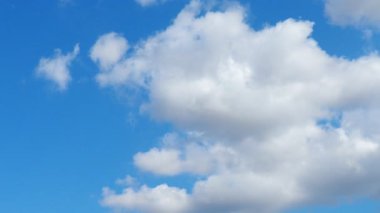 Güneşli mavi gökyüzünde güzel beyaz bulutlar. Ses ötesi ışık efekti. Troposferde korunma. Gerçek zamanlı ağır çekim. Kümülüs bulutları düşük seviye, kabarık, pamuk gibi, tüylü Cumulonimbus.