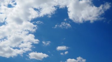 Güneşli mavi gökyüzünde güzel beyaz bulutlar. Ses ötesi ışık efekti. Troposferde korunma. Gerçek zamanlı ağır çekim. Kümülüs bulutları düşük seviye, kabarık, pamuk gibi, tüylü Cumulonimbus